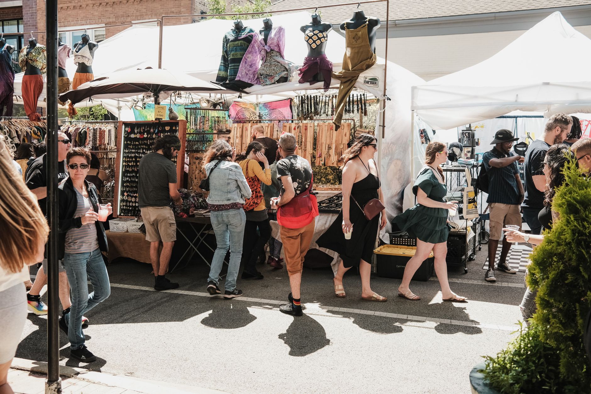 Busy outdoor market in Chicago, showcasing diverse goods and shoppers enjoying a sunny day.