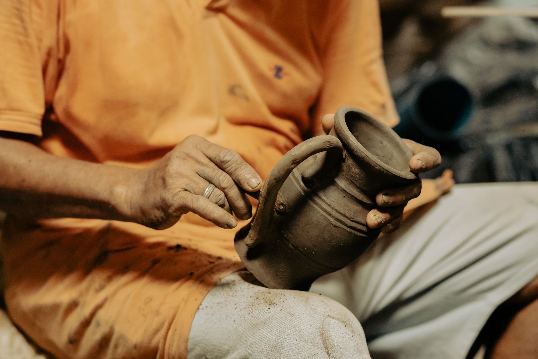 Intricate view of an artisan shaping a clay pot by hand, showcasing traditional craftsmanship.