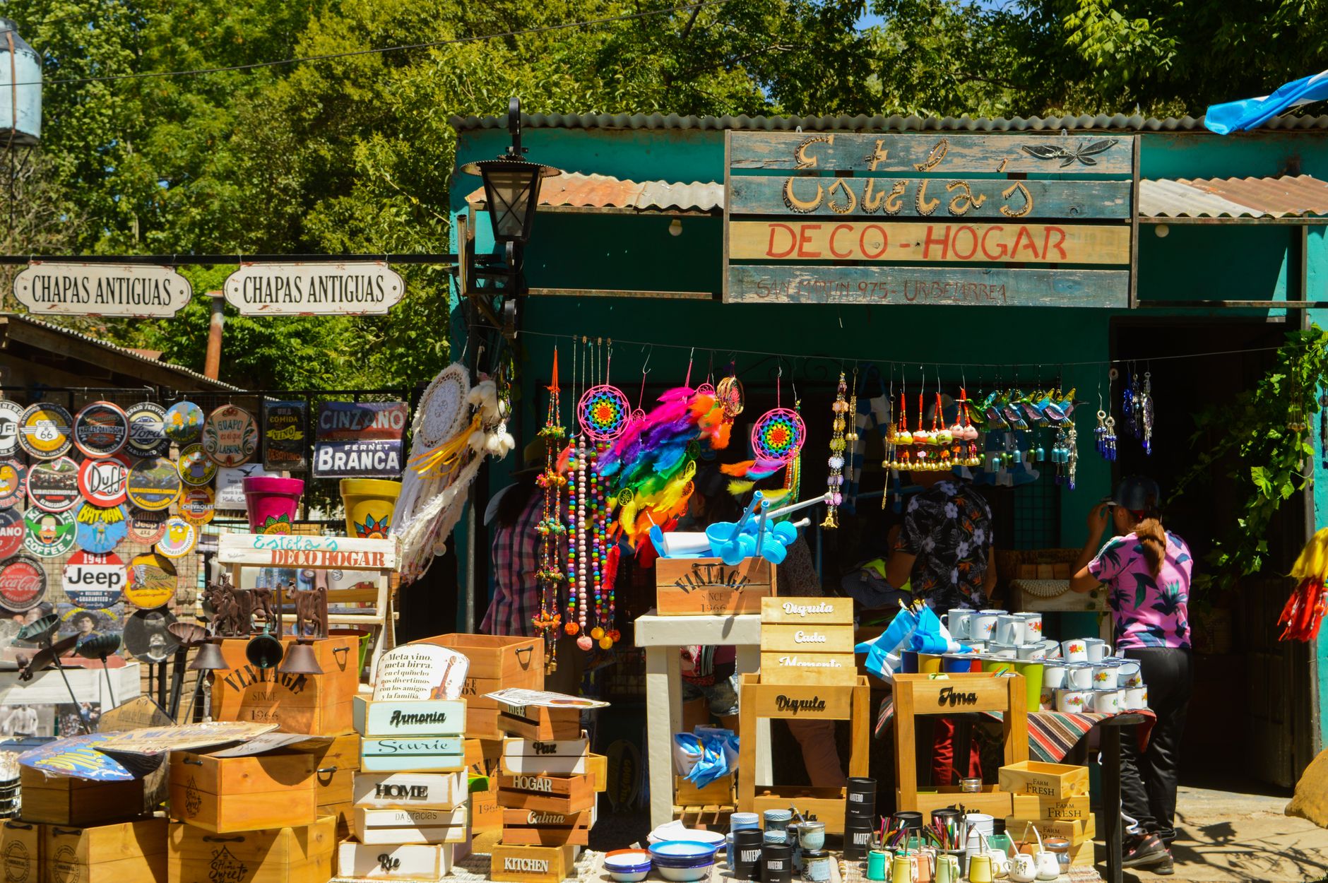 Lively street market in a sunny setting showcasing vintage home decor and crafts.