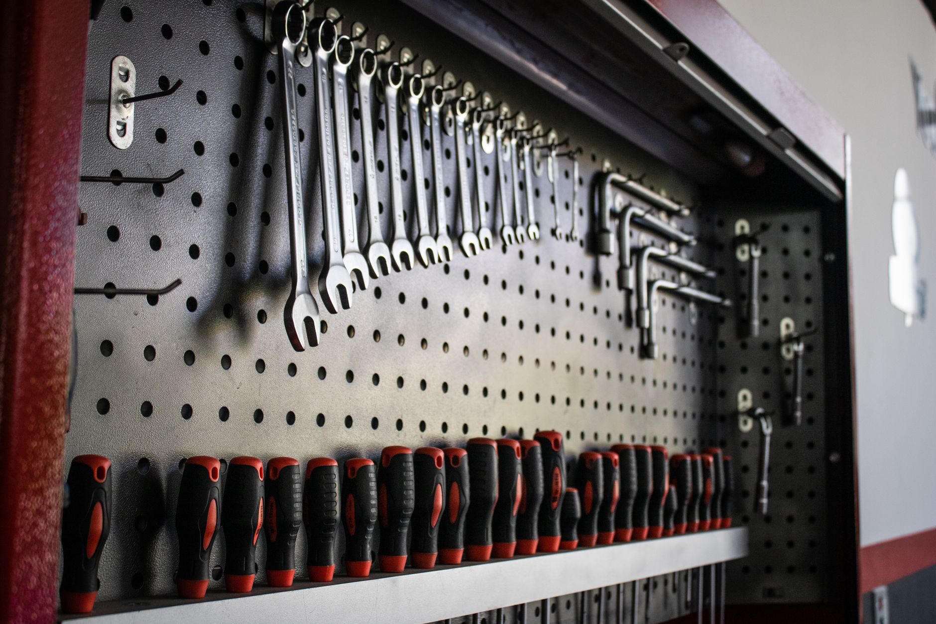 A collection of hand tools neatly arranged on a pegboard for easy access and organization.