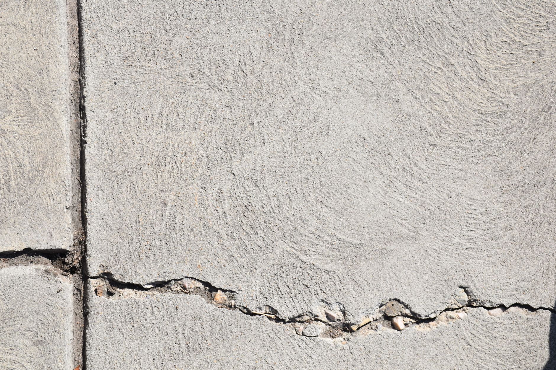 Close-up view of a cracked concrete surface with distinct textures in Logan, Utah.