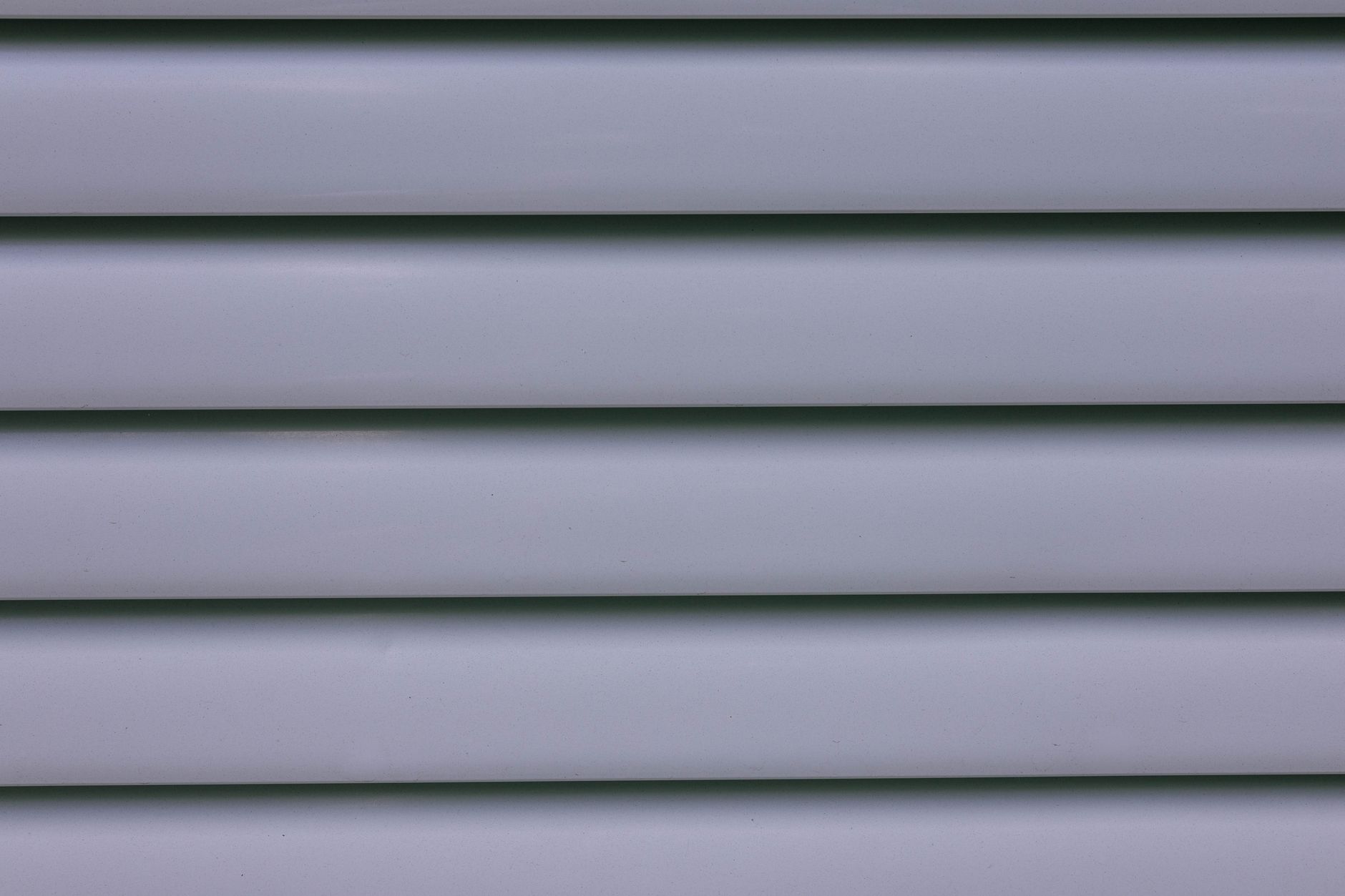 Detailed close-up of gray layered wall paneling showing lines and shadows.