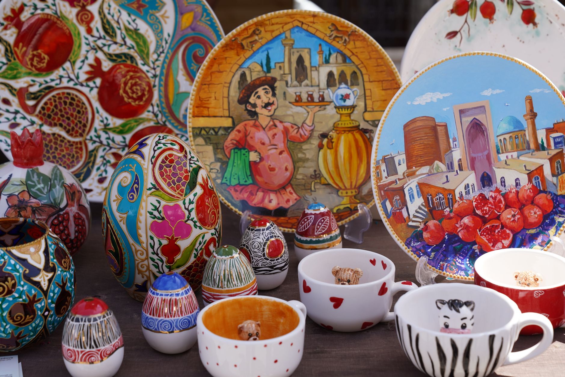Vibrant display of handcrafted ceramic plates and cups featuring cultural designs and intricate artistry.