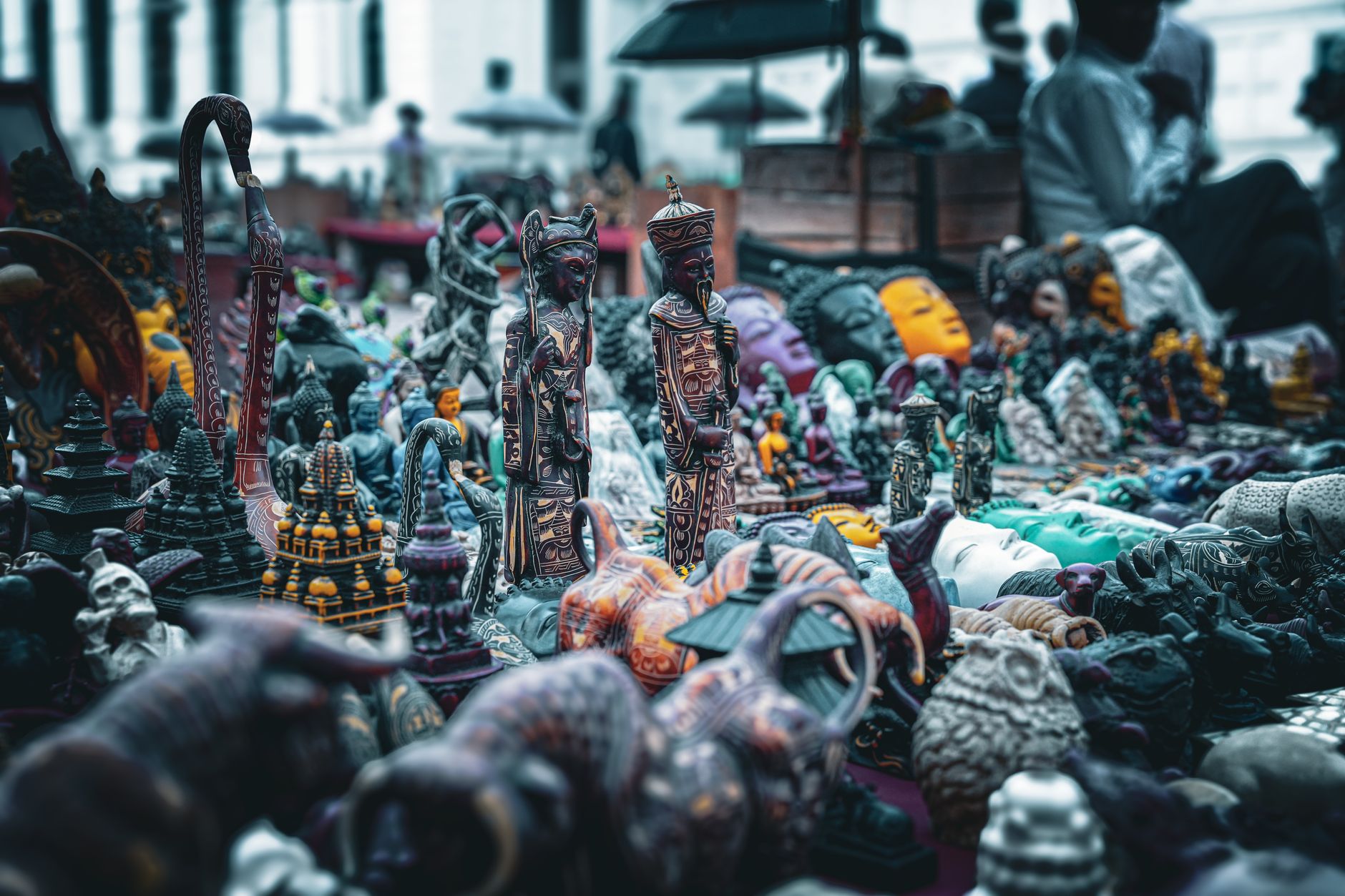 A diverse array of handmade figurines displayed at an outdoor market stall.