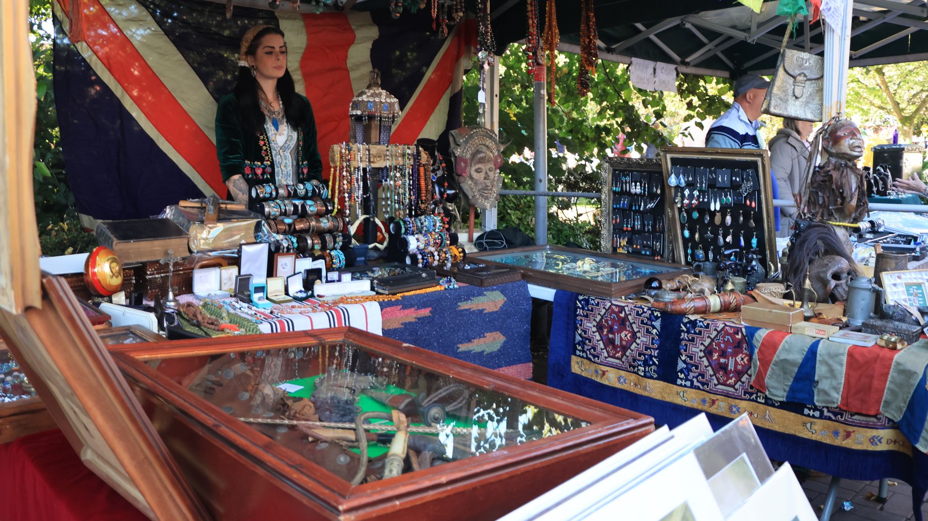 A colorful artisan market stall displaying jewelry and crafts in Nantwich, England.