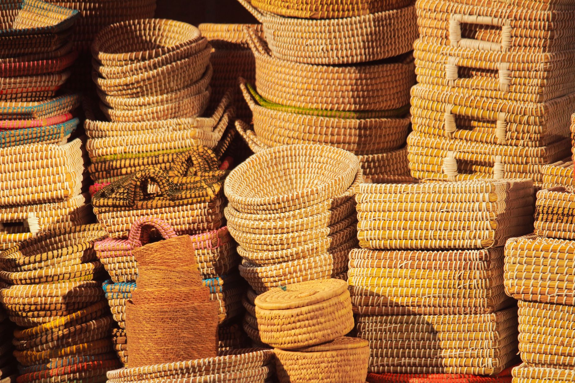 Vibrant handmade woven baskets stacked in a market, showcasing craftsmanship.