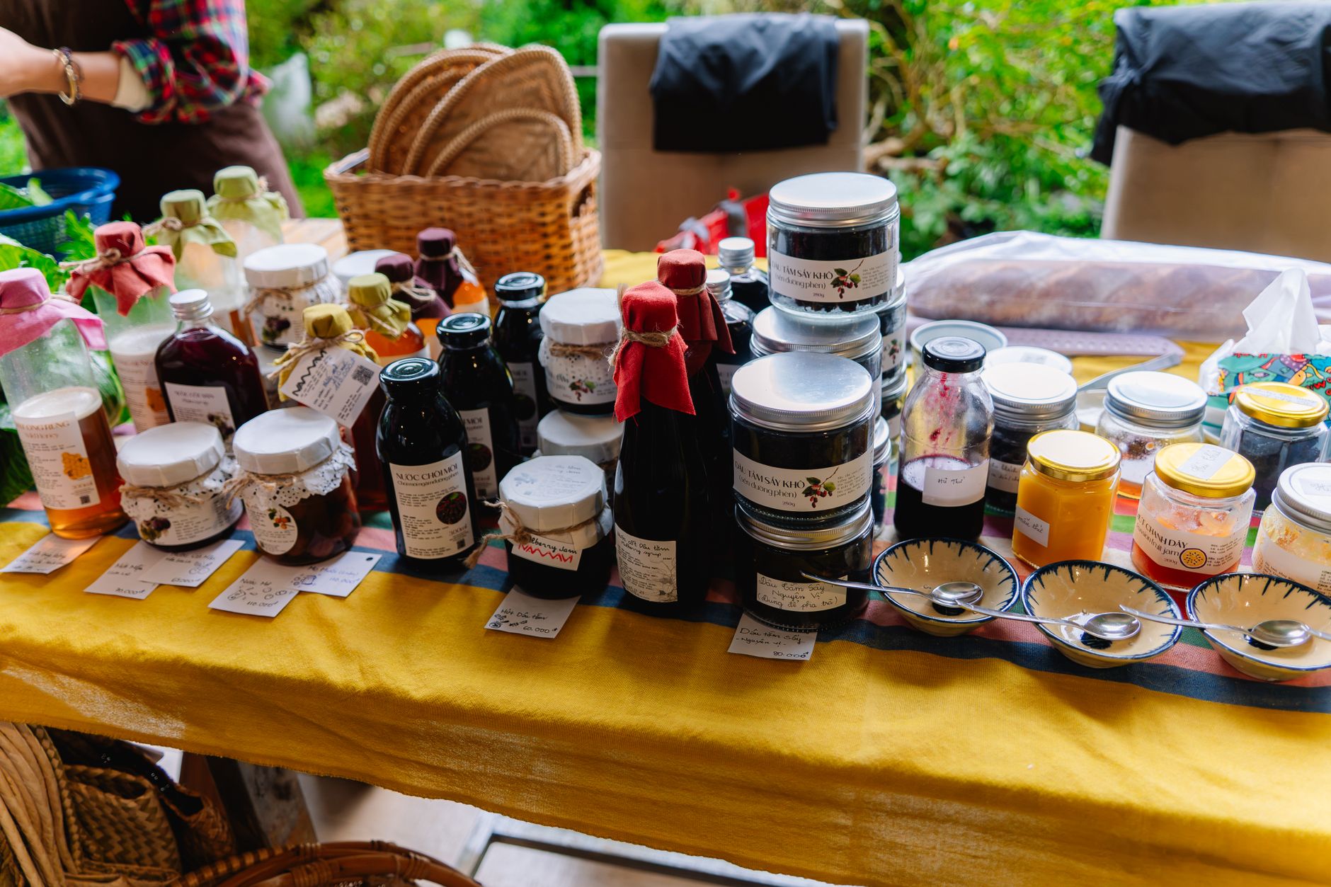 Colorful display of various homemade jams and preserves at a vibrant outdoor market.