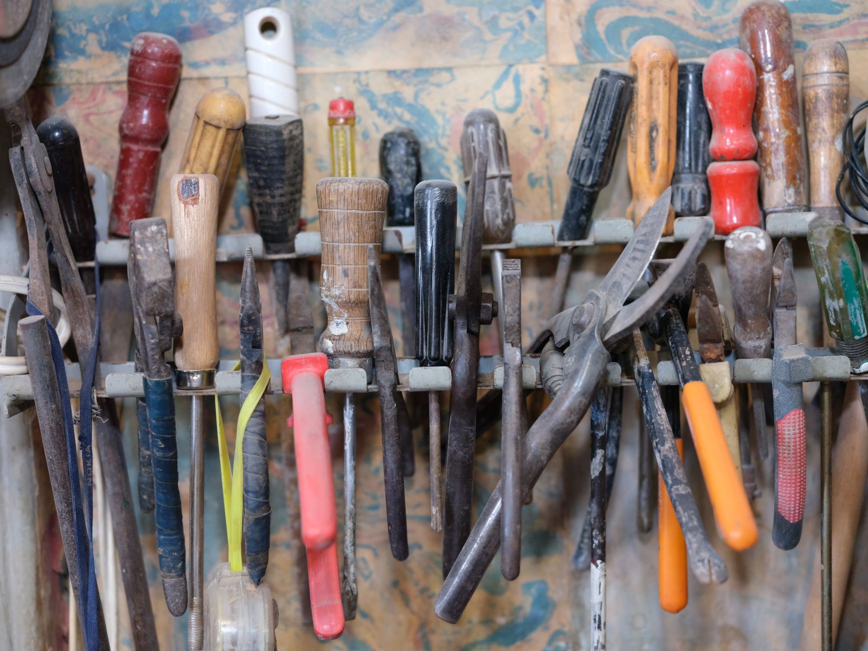 A collection of various tools neatly arranged on a workshop rack, showcasing a DIY environment.